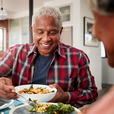 Senior man filling plate at table