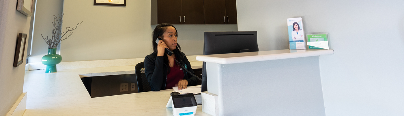 Little Elm dental team member answering the phone at the front desk