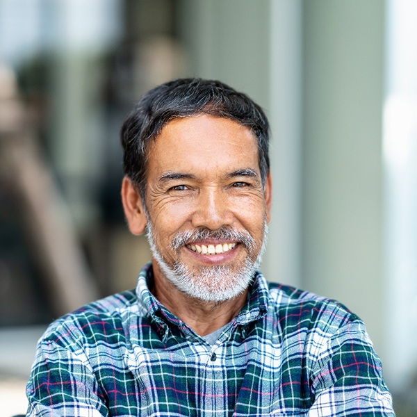 Bearded man sitting outside and smiling