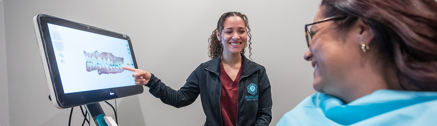 Dental team member showing a patient a digital impression of their teeth