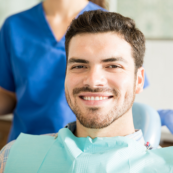 Man with short facial hair smiling in the dental chair
