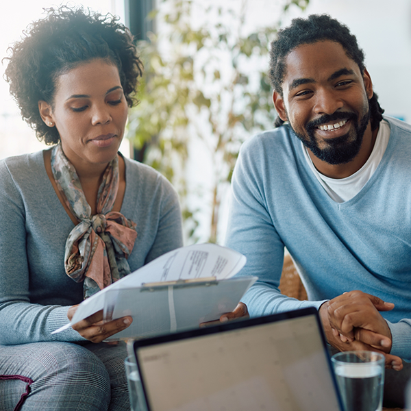 Man and woman sitting on a couch and looking at paperwork