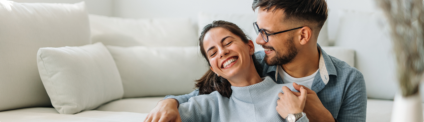Man and woman smiling together at home after cosmetic dentistry in Little Elm