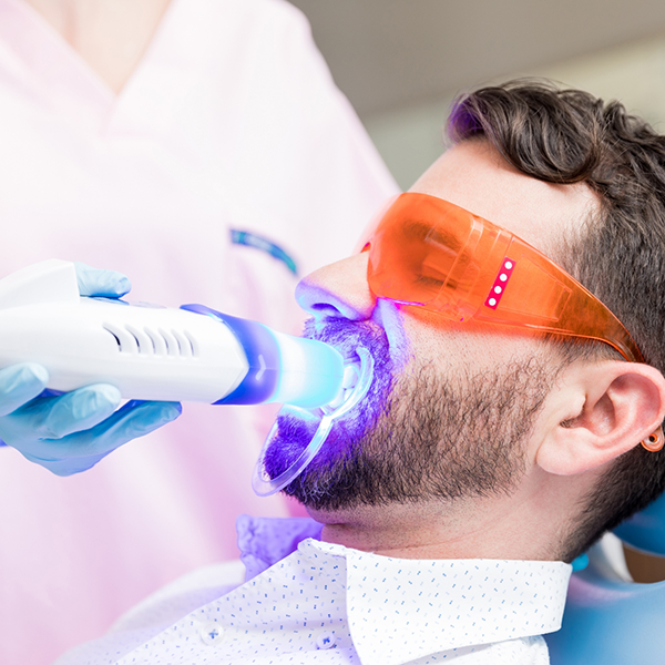 Man in the dental chair getting professional teeth whitening