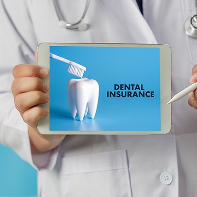 Dentist holding tablet displaying dental insurance