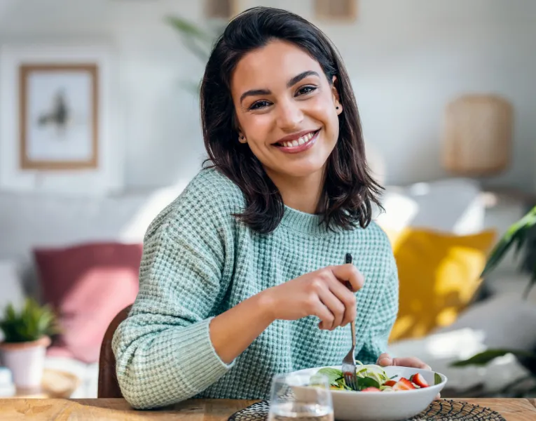 Smiling woman holding a salad bowl