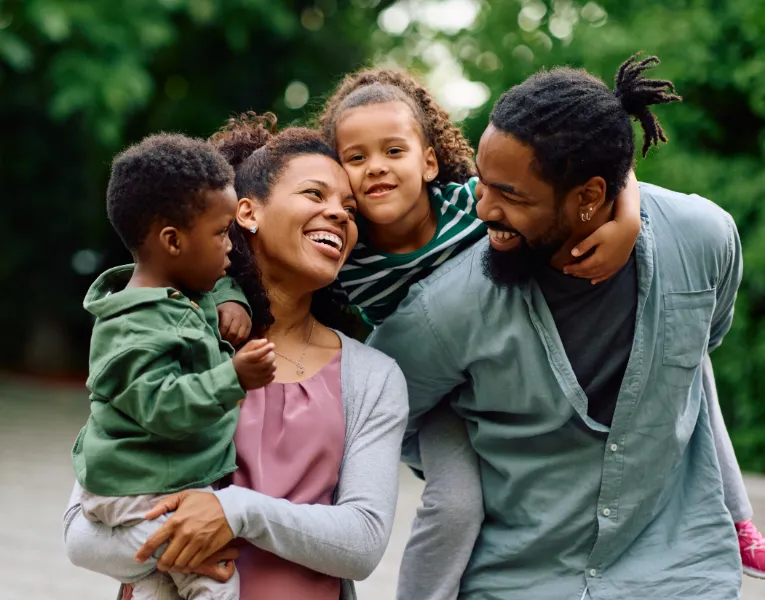 Family of four laughing together outdoors