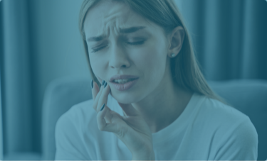 Woman holding the side of her jaw in pain